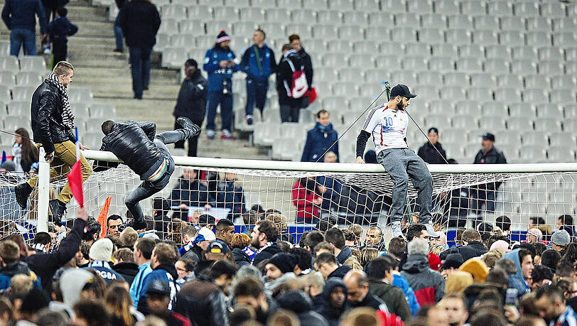 Vor neun Jahren harren Fußballfans aus Frankreich und Deutschland nach einem Testspiel der beiden Nationalmannschaften auf dem Rasen des Stade de France in Paris aus. Außerhalb der Arena verüben Terroristen ein Massaker. Aktuell ist die Bedrohungslage wieder hoch.