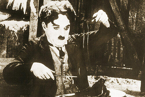 Der Hunger treibt&rsquo;s rein: Charlie Chaplin beim Schuhe essen.