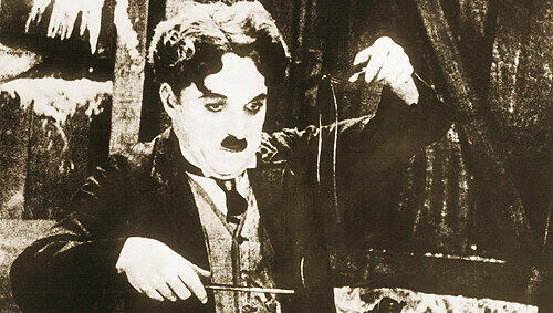 Der Hunger treibt’s rein: Charlie Chaplin beim Schuhe essen. Der Hunger treibt’s rein: Charlie Chaplin beim Schuhe essen.