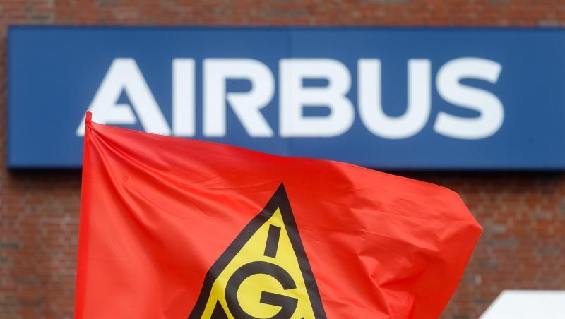 Eine Fahne der IG-Metall weht bei einem Warnstreik vor dem Schriftzug "Airbus".