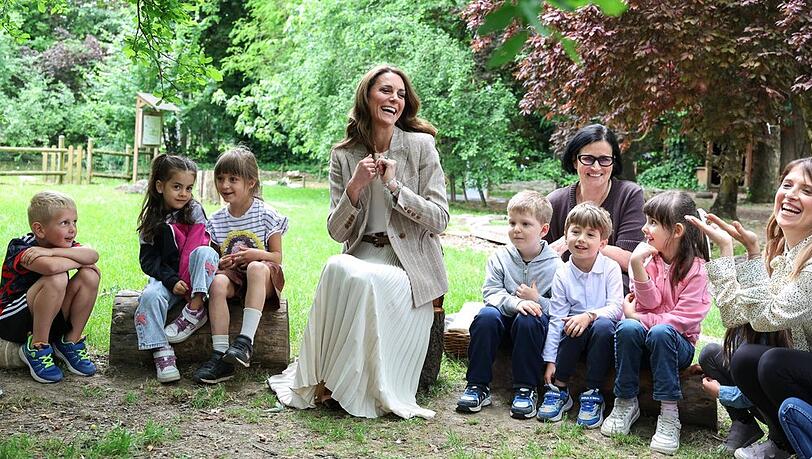Prinzessin Kate mit Schulkindern in einem Garten.