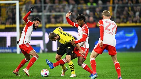 Dortmunds Julian Ryerson (2.v.l) in Aktion gegen Münchens Spieler Noussair Mazraoui (l-r), Kingsley Coman und Konrad Laimer.