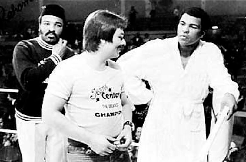 Waldemar Hartmann (M.) im Ring mit Muhammad Ali (r.), der 1976 in der Münchner Olympiahalle gegen Richard Dunn boxte.
