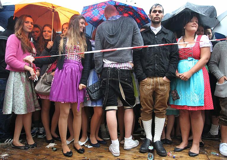 Trotz Sauwetter und Regen warten bereits viele Wiesngänger auf den Wiesnanstich. Der Kampf um den Platz im Bierzelt beginnt schon am frühen Morgen. Die ersten Bilder.