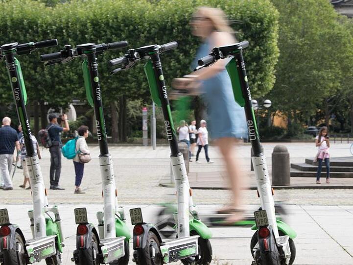 Eine Frau fährt auf vor auf einem E-Scooter des Anbieters Lime. E-Scooter müssen auf dem Festland bleiben, sie werden auf der autofreien Ostseeinsel Hiddensee nicht geduldet.