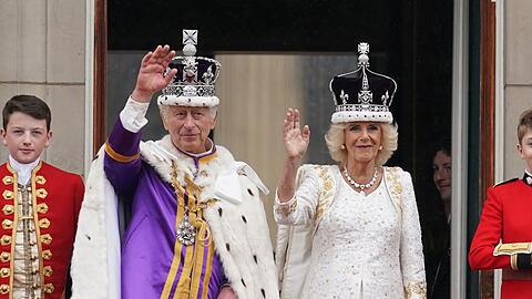 Die frisch gekrönten König Charles III. und Königin Camilla winken vom Balkon des Buckingham Palastes der Menge zu.