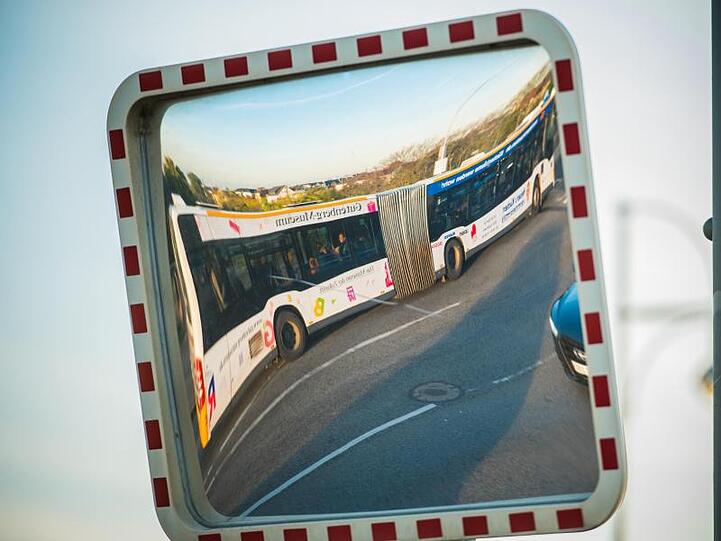 Ein Stadtbus spiegelt sich in einem Verkehrsspiegel. Foto: Andreas Arnold/dpa