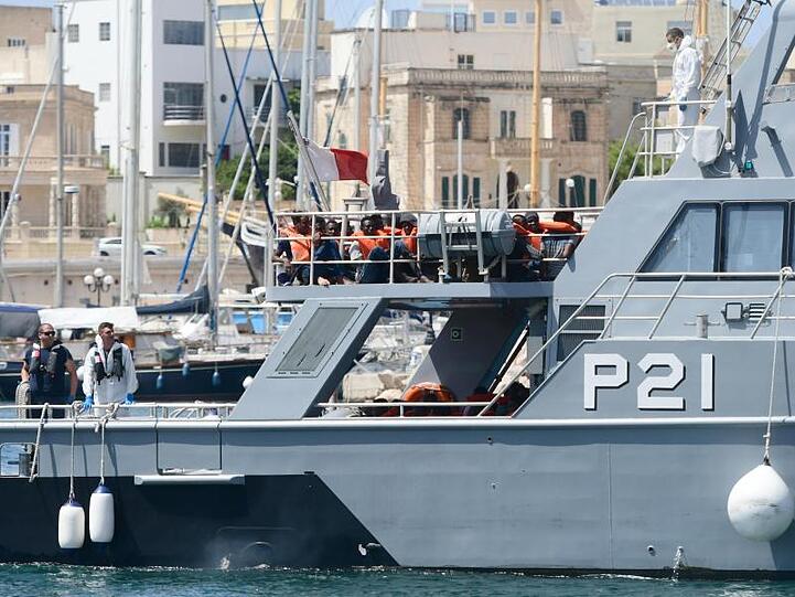 Gerettete Migranten sitzen auf dem Deck eines Patrouillenboot der maltesischen Streitkräfte.