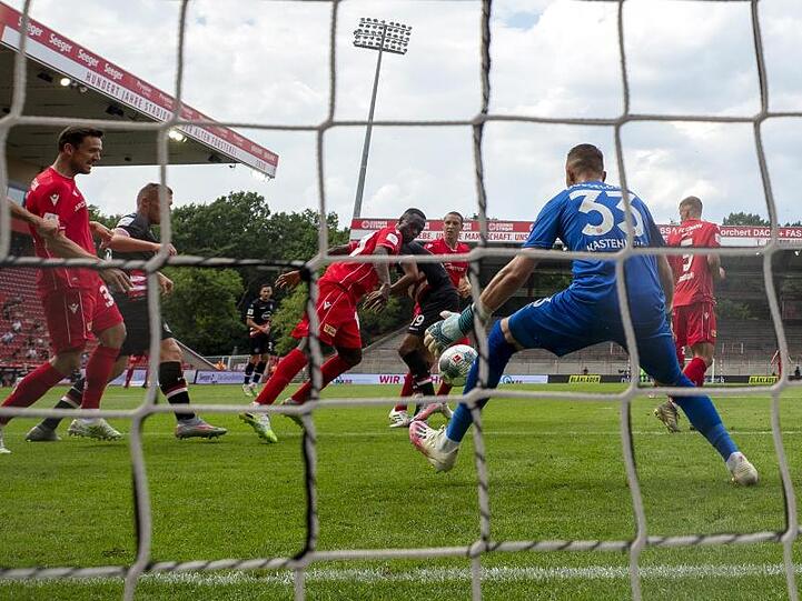 Anthony Ujah (M) erzielt das 1:0 für Union Berlin vorbei an Torwart Florian Kastenmeier von Fortuna Düsseldorf.