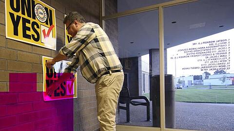 Brian Rothenburg von der Gewerkschaft United Auto Workers klebt vor der Abstimmung Ja-Poster.