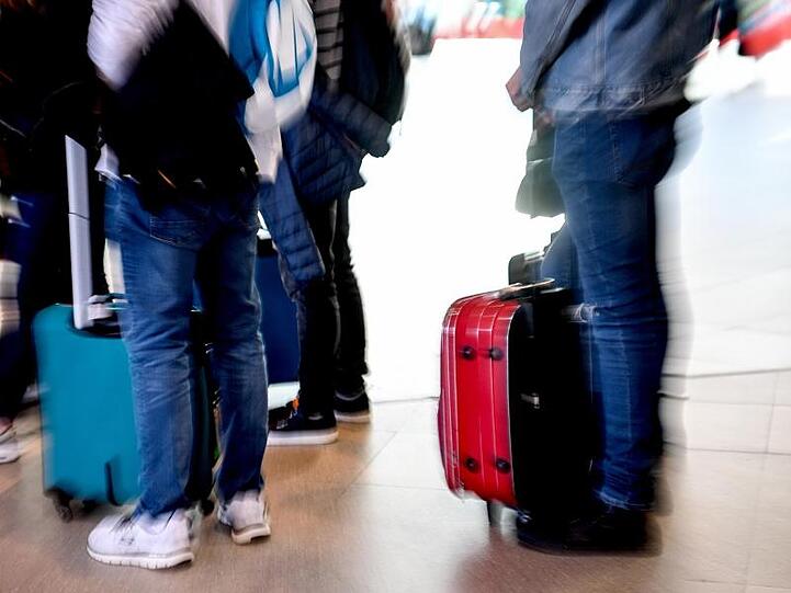 Reisende warten auf dem Flughafen. Foto: Britta Pedersen/Archivbild