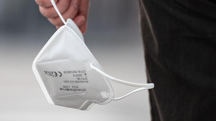 Ein Passant trägt eine FFP2-Maske in der Hand. (Symbolbild)