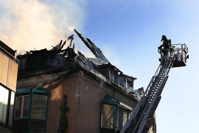 Rauch steigt am Donnerstag aus dem Dachstuhl eines Hauses in der Innenstadt von Würzburg. In den frühen Morgenstunden war der Dachstuhl in Brand geraten. Knapp 100 Feuerwehrleute waren zur Brandbekämpfung im Einsatz.