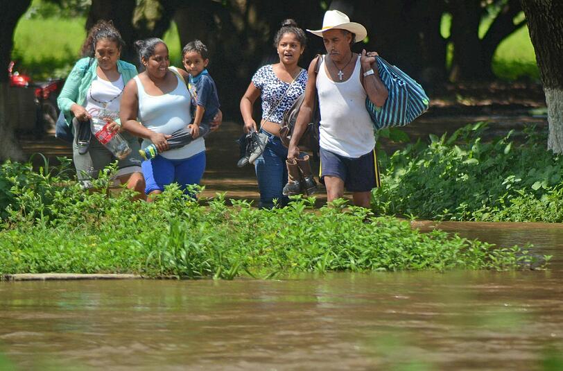 Das Wasser steht den Menschen bis zu den Knien. Der Sturm kam am Donnerstag von der Karibik über Belize nach Mexiko.