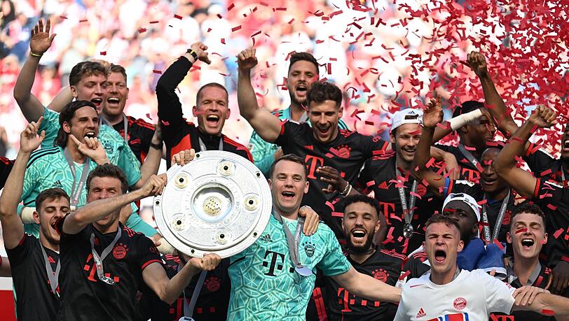Bayerns Torhüter Manuel Neuer (M) hält die Meisterschale während seine Teamkollegen jubeln.