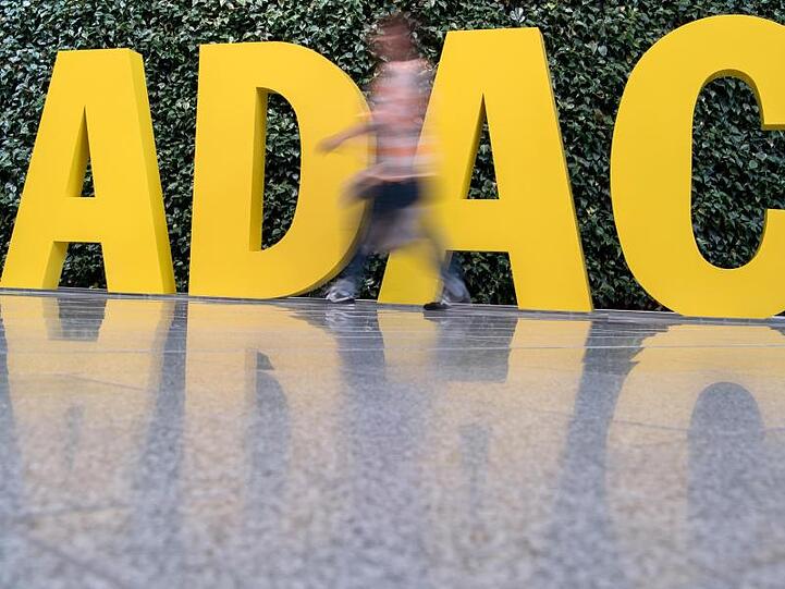Ein Frau geht vor dem ADAC-Logo entlang.