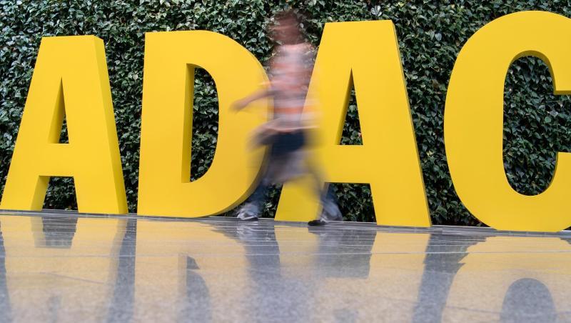 Ein Frau geht vor dem ADAC-Logo entlang. Ein Frau geht vor dem ADAC-Logo entlang.