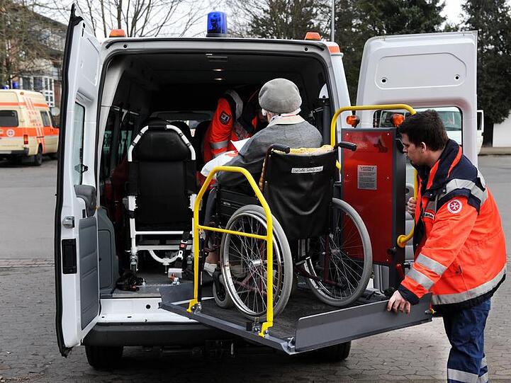 Die Bewohnerin eines Seniorenheims wird aus der Gefahrenzone gebracht.