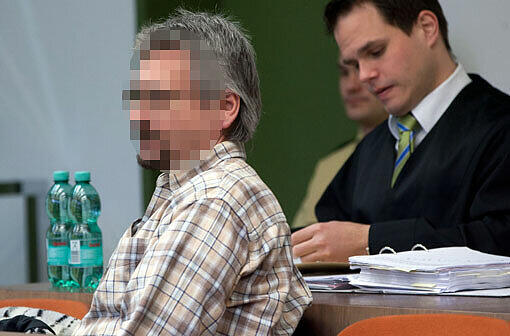 Der Angeklagte Max P. (51) auf der Anklagebank des Münchner Landgerichts. Hinter ihm sitzt sein Strafverteidiger, der die Akten wälzt.