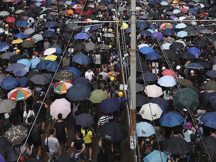 Mit Regenschirmen protestieren Hongkonger gegen die Regierung und einen Angriff von Schlägertrupps eine Woche zuvor.