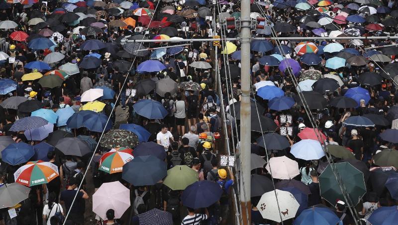 Mit Regenschirmen protestieren Hongkonger gegen die Regierung und einen Angriff von Schlägertrupps eine Woche zuvor.