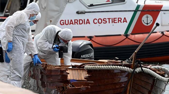 Italienische Forensiker begutachten den Schaden an einem Boot.