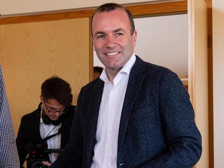 Manfred Weber (r., CSU) wirft seinen Stimmzettel für die Europawahl in eine Wahlurne. Foto: Sven Hoppe