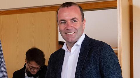 Manfred Weber (r., CSU) wirft seinen Stimmzettel für die Europawahl in eine Wahlurne. Foto: Sven Hoppe