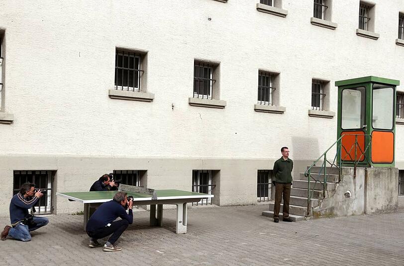 Eine Tischtennisplatte steht vor einem Gefängnisgebäude.