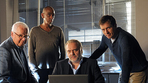 Gerd Heymann (Michael Ande, l.), Axel Richter (Pierre Sanoussi-Bliss, 2.v.l. ), Hauptkommissar Richard Voss (Jan-Gregor Kremp, 2.v.r.), Werner Riedmann (Markus Böttcher, r.)