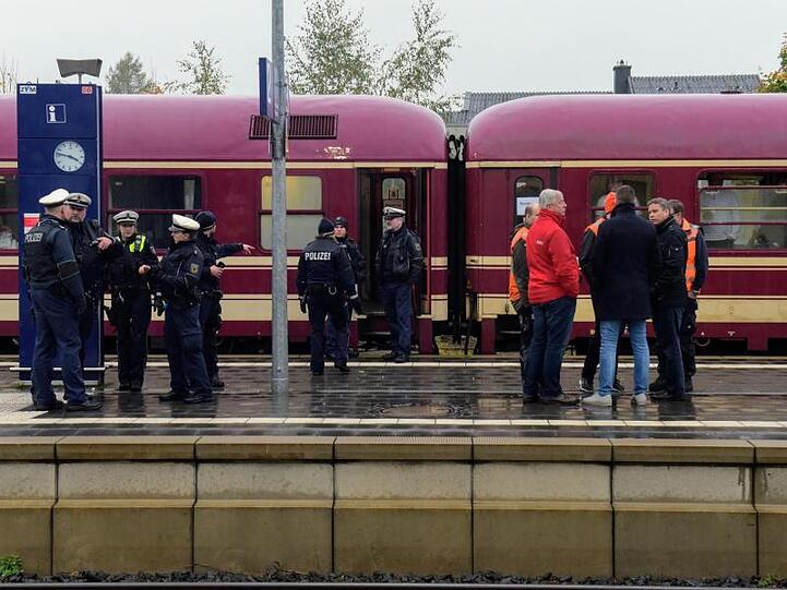 Poizisten und Reisende stehen am Freitag neben dem Partyzug, nachdem er in Greven gestoppt wurde.