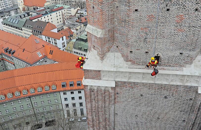 Da bekommt man feuchte Hände: Der Feuerwehrmann hängt an einem Seil und rettet den Falken. Er hatte sich 80 Meter vom Turm abgeseilt.