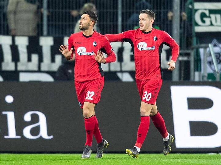 Torschütze Vincenzo Grifo (l) feiert mit seinem Teamkollegen Christian Günter den Treffer gegen Gladbach.