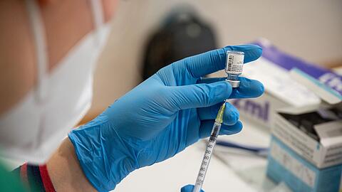Die Mitarbeiterin eines mobilen Impfteams bereitet eine Impfung gegen das Coronavirus vor.