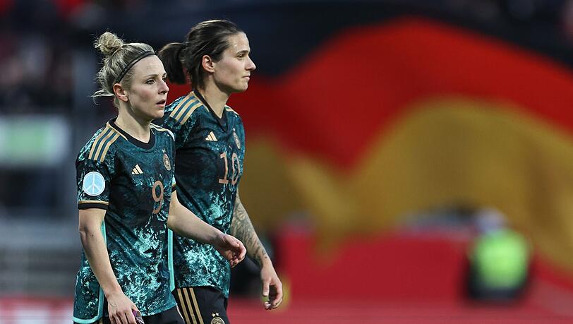 Svenja Huth (l) und Dzsenifer Marozsan aus Deutschland gehen nach dem Abpfiff über den Rasen.