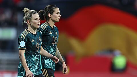 Svenja Huth (l) und Dzsenifer Marozsan aus Deutschland gehen nach dem Abpfiff über den Rasen.