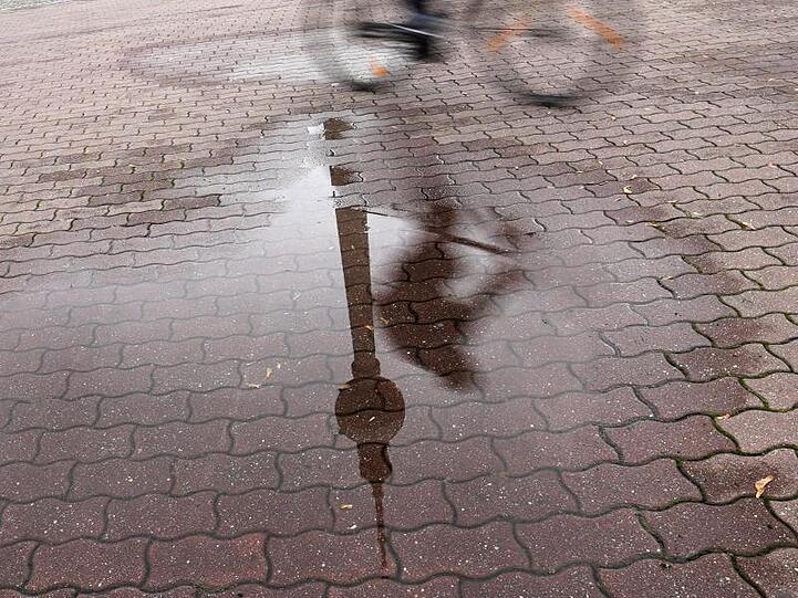 In einer Regenpfütze in Berlin spiegelt sich der Fernsehturm. .