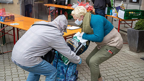 Eine Helferin in Fürth packt einem Bürger Hygieneartikel in die Tasche. Wegen der Preissteigerungen droht eine soziale Krise, sagt der VdK.