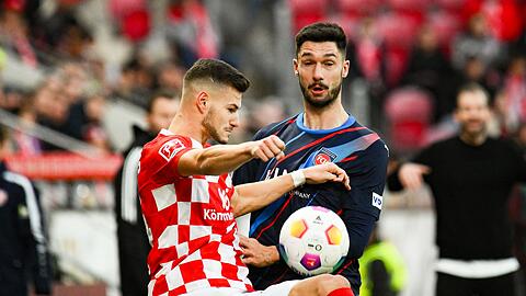 Der Mainzer Tom Krauss (l) liefert sich mit Heidenheims Tim Kleindienst einen Zweikampf um den Ball.