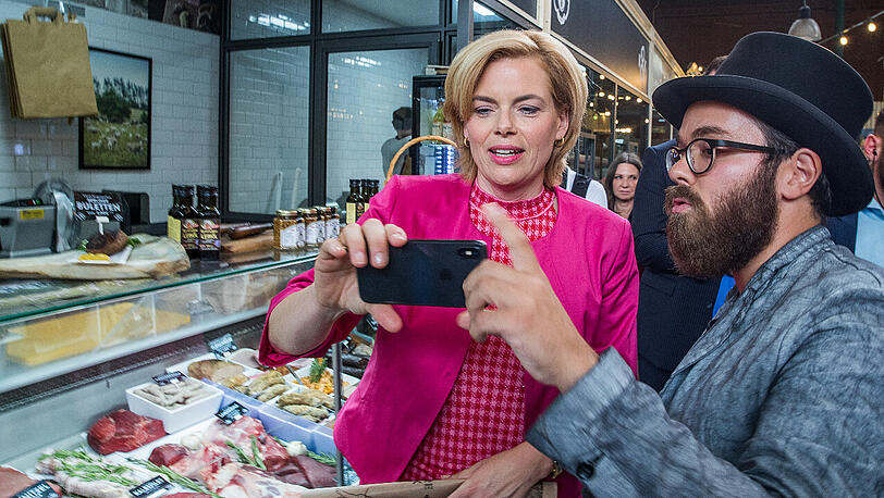 Julia Klöckner, Bundesministerin für Ernährung und Landwirtschaft, spricht mit Metzger Hendrik Haase an dessen Stand in der Markthalle 9 in Berlin.