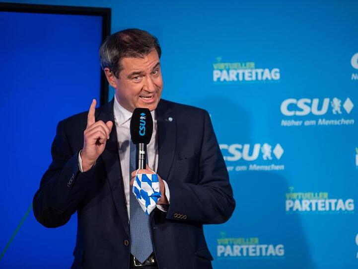 Markus Söder (CSU) steht beim virtuellen CSU-Parteitag auf einer Bühne. Foto: Lino Mirgeler/dpa-Pool/dpa