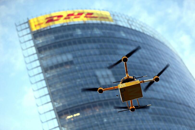 Eine Drohne der Deutschen Post fliegt in Bonn (Nordrhein-Westfalen) mit einem Paket. Die Deutsche Post DHL hat erstmals einen Drohnen-Einsatz fü?r die Paketzustellung getestet.