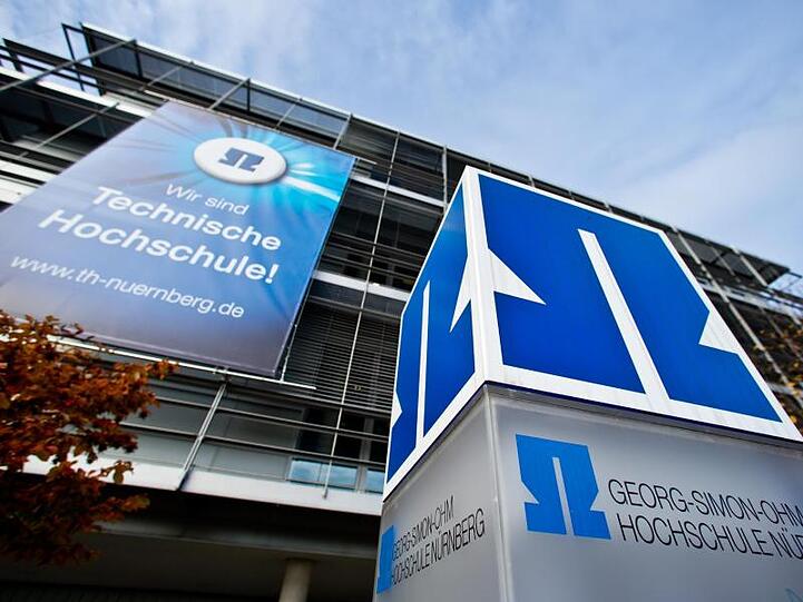 Blick auf den alten und neuen Schriftzug der technischen Hochschule Nürnberg. Foto: Daniel Karmann/dpa/Archivbild