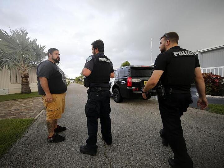 Polizeibeamte sprechen mit einem Anwohner in Florida über die bevorstehende Evakuierung.