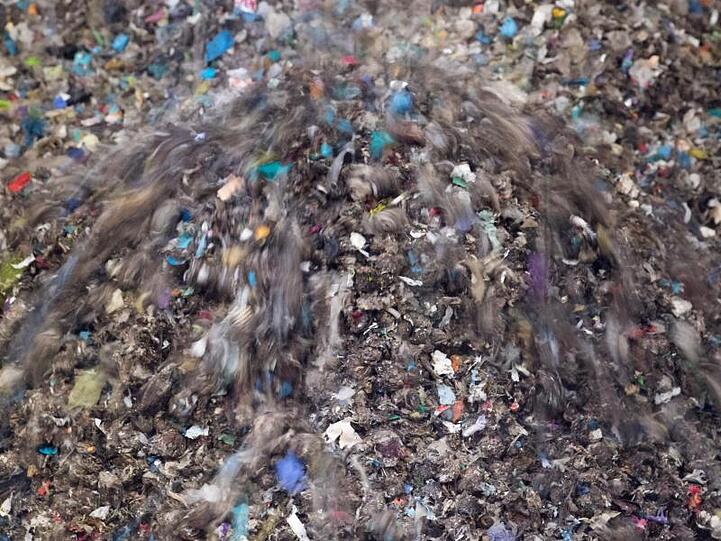 Gepresste Pellets aus Abfall rieseln in der Restabfallbehandlungsanlage in Chemnitz in einen Container.
