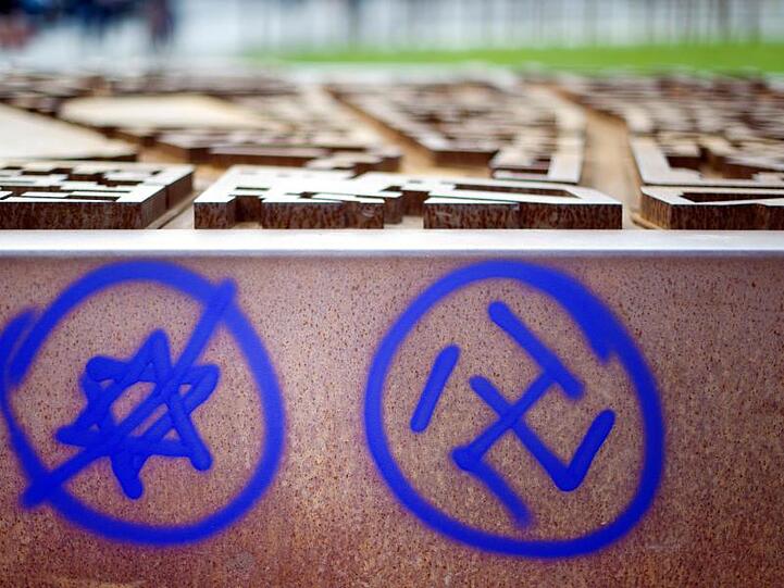 Ein Hakenkreuz und ein durchgestrichener Davidstern sind an einer Gedenkstätte zu sehen. Foto: Daniel Reinhardt/dpa/Archivbild