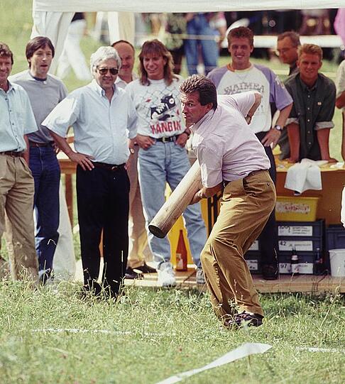 Jupp Heynckes probiert sich im Baumstammwerfen. Anlass dazu war das Sommerfest des FC Bayern, 1990.