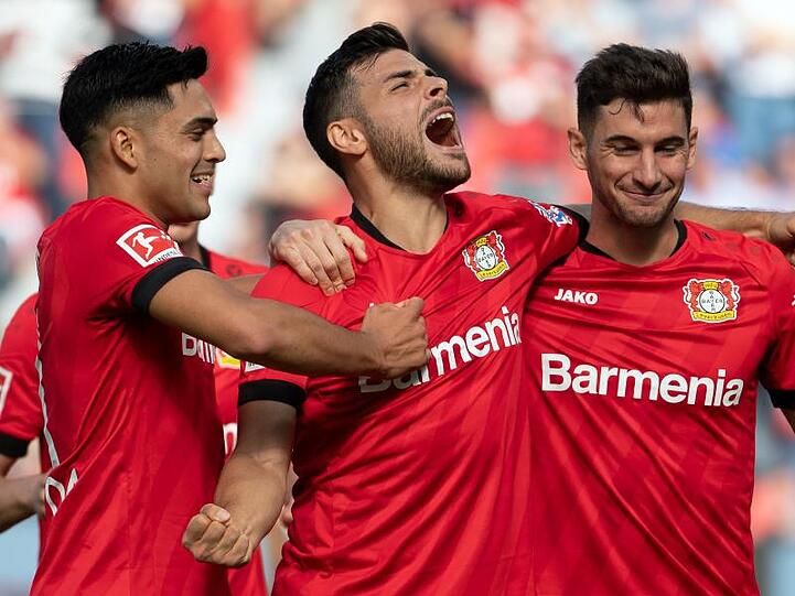 Torschütze Kevin Volland (M) jubelt mit Nadiem Amiri (l) und Lucas Alario (r) über das 1:0 gegen Union Berlin.