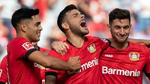 Torschütze Kevin Volland (M) jubelt mit Nadiem Amiri (l) und Lucas Alario (r) über das 1:0 gegen Union Berlin.