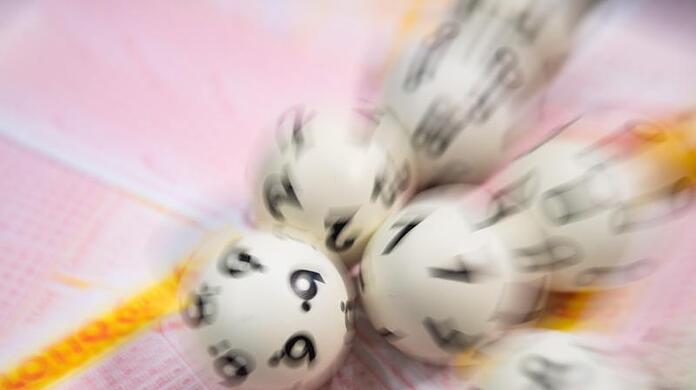 Lotto-Kugeln liegen auf einem Lottoschein.